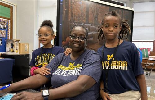  three people sitting and standing